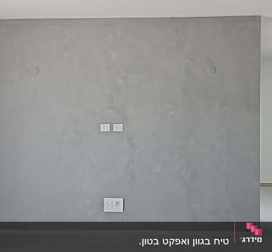 קיר צבוע באפור עם שקעים לשקעים חשמליים